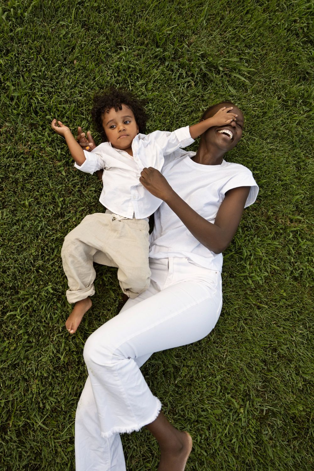 A parent and child playing together on the grass